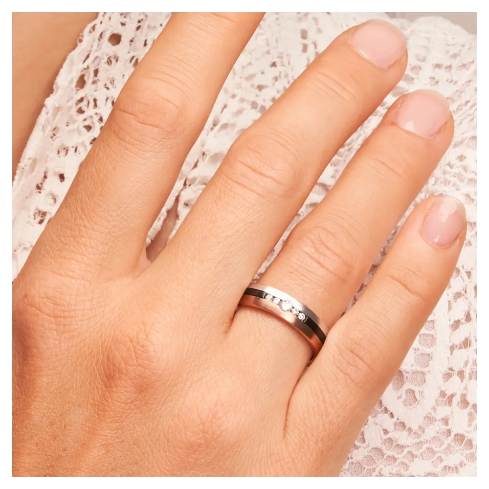 Trauring aus Weißgold&Roségold&Zirkonium mit fünf Diamanten auf Hand am Gesicht im Zoom
