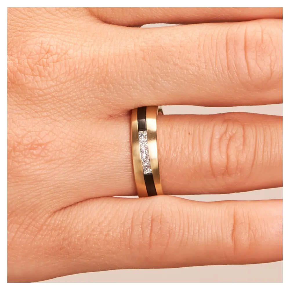 Trauringe aus Gelbgold & Zirkonium bicolor mit fünf Diamanten auf Hand im Zoom