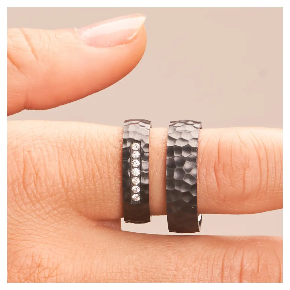 Eheringe aus Zirkonium mit Hammerschlag und 7 Diamanten auf Hand im Zoom