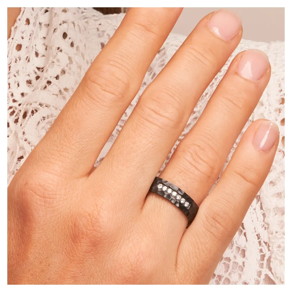 Ehering aus Zirkonium mit Hammerschlag und 7 Diamanten auf Hand am Gesicht im Zoom