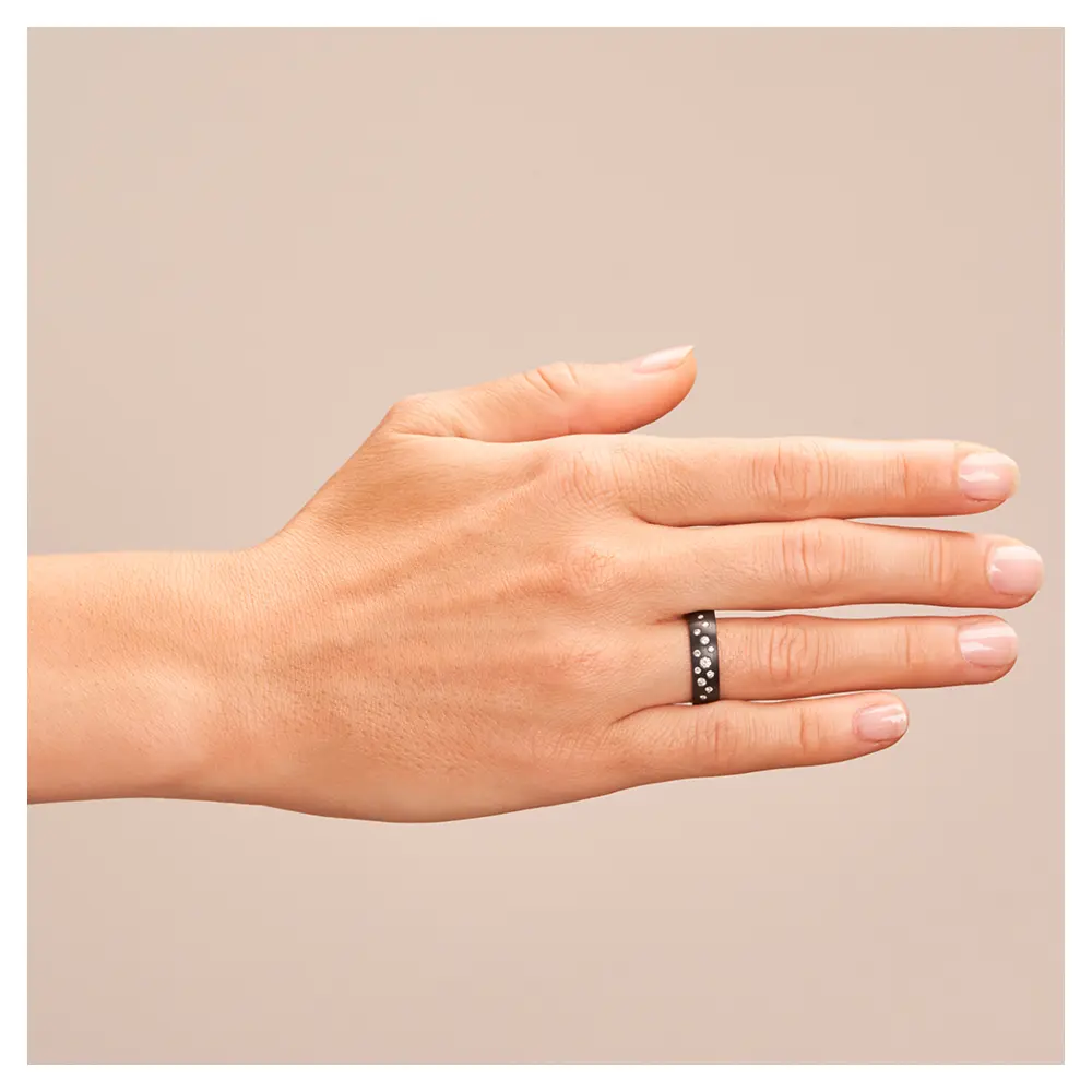 Ehering aus schwarzem längsmattem Zirkonium mit vielen weißen Diamanten auf Hand