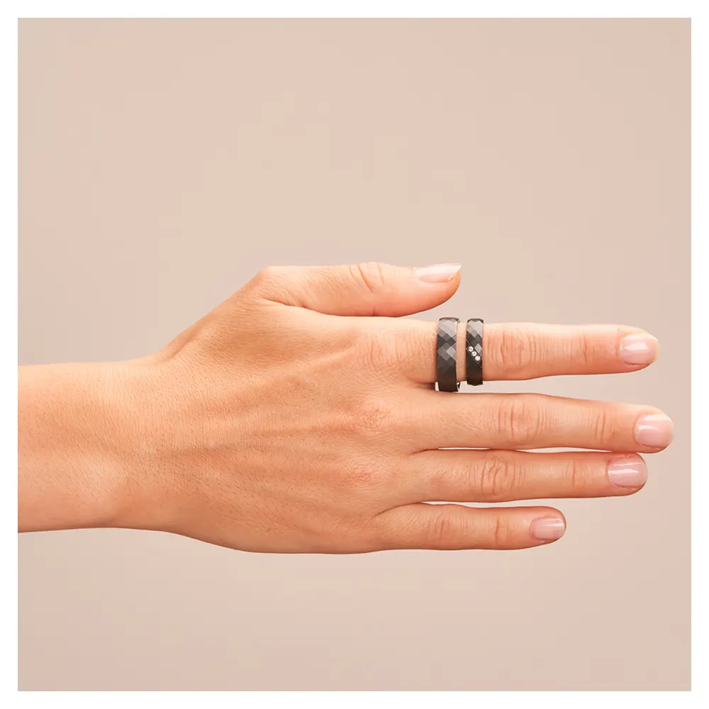 Eheringe aus Zirkonium mit strukturierter Oberfläche und 3 Diamanten auf Hand 