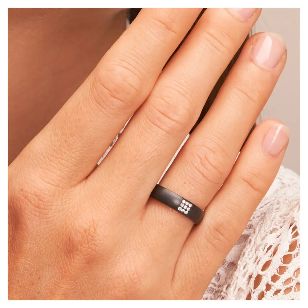 Ehering aus Zirkonium mit Diamanten als strahlendes Quadrat auf Hand am Gesicht im Zoom