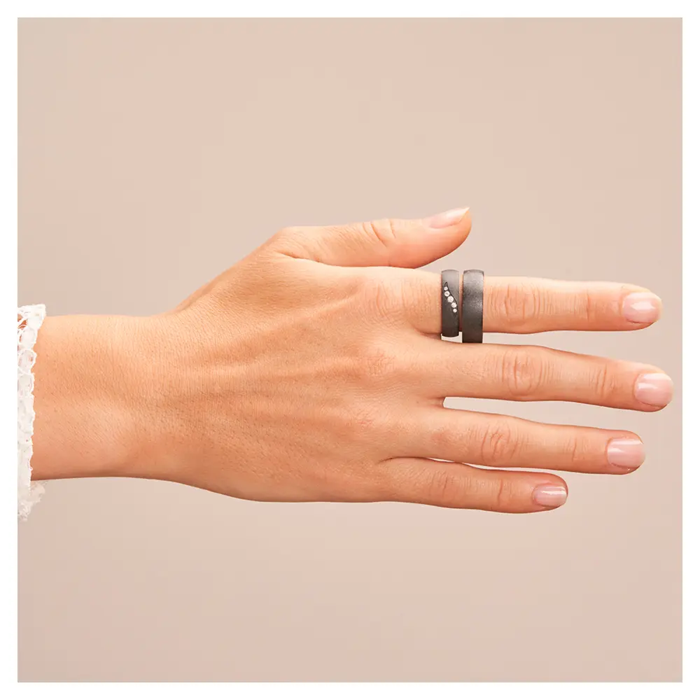 Schimmernde schwarze Eheringe aus Zirkonium mit fünf Diamanten auf Hand