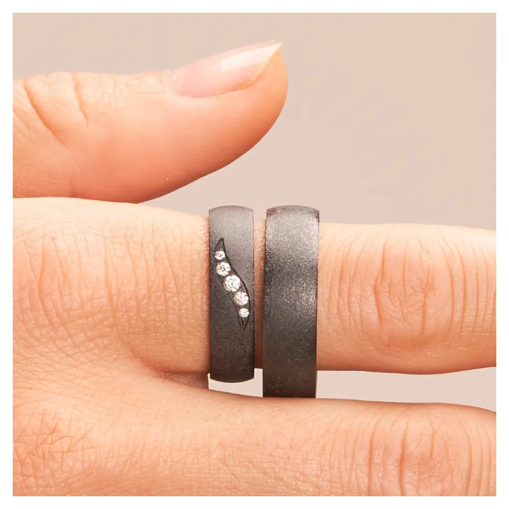 Schimmernder schwarzer Ehering aus Zirkonium mit fünf Diamanten auf Hand im Zoom