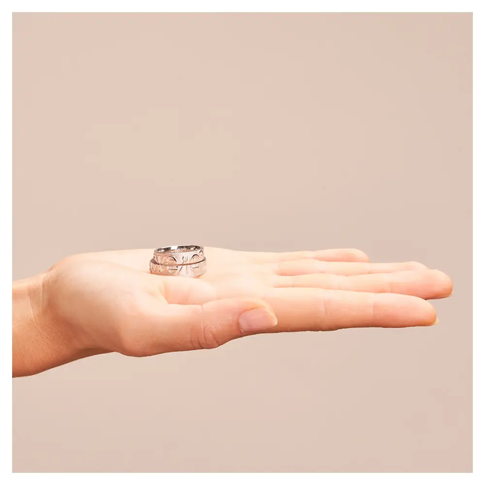 Eheringe aus Weißgold mit Forever-Schriftzug und weißem Brillant auf Hand horizontal