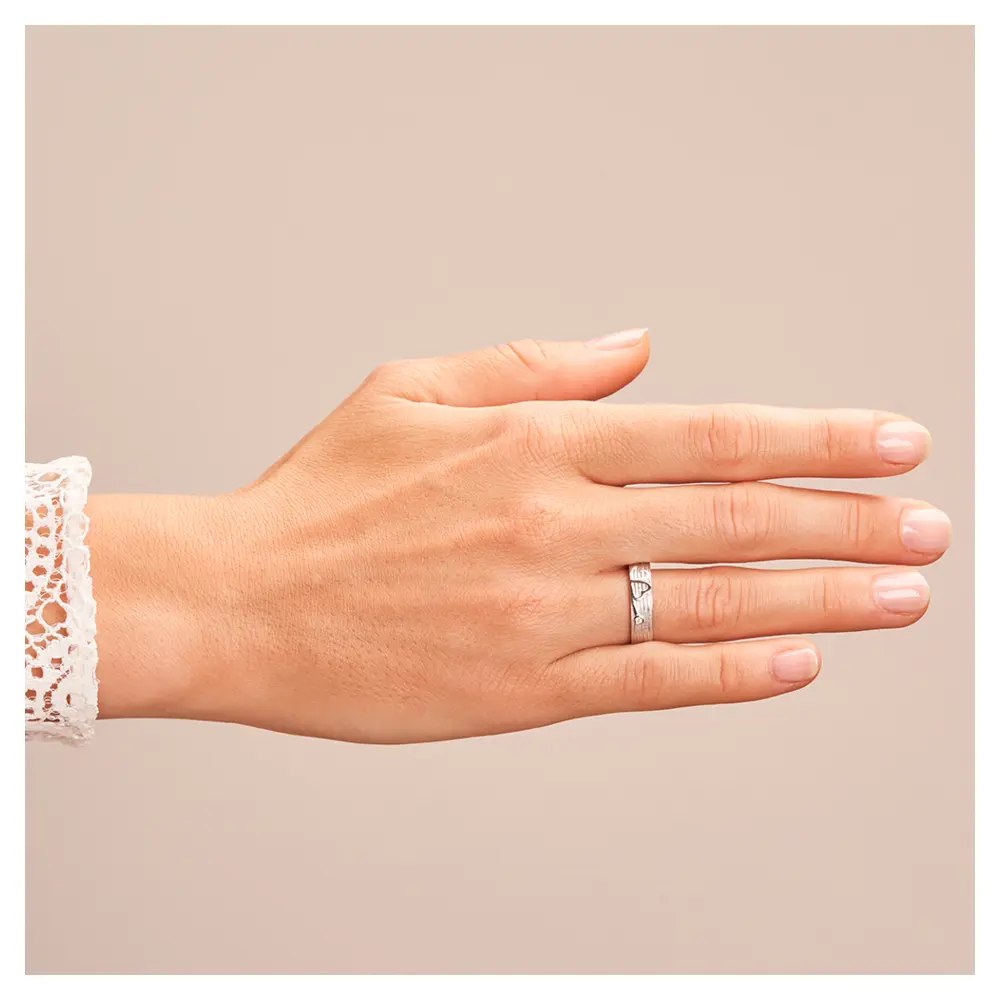 Ehering aus Weißgold mit einem Kleeblatt als Symbol und Diamant auf Hand
