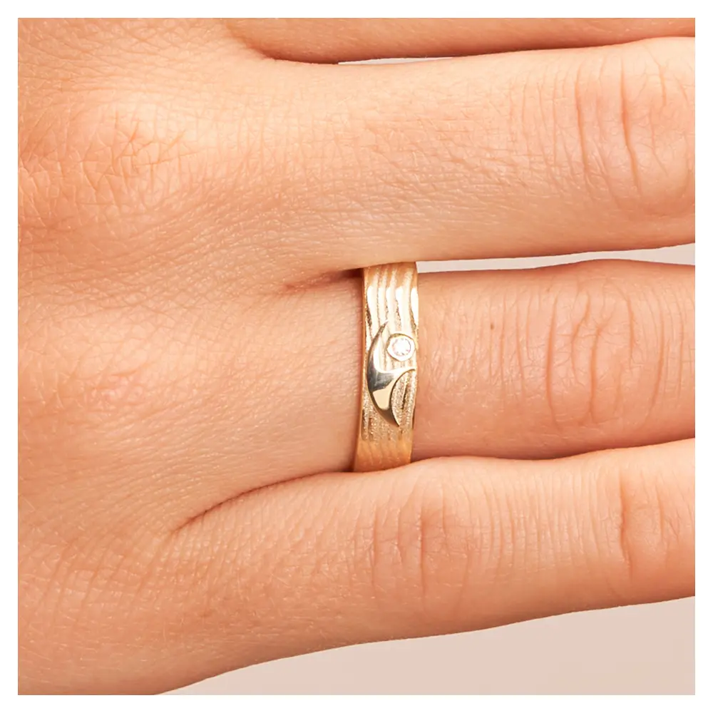 Ehering aus Gelbgold mit interessantem Paarfigur-Symbol auf Hand im Zoom