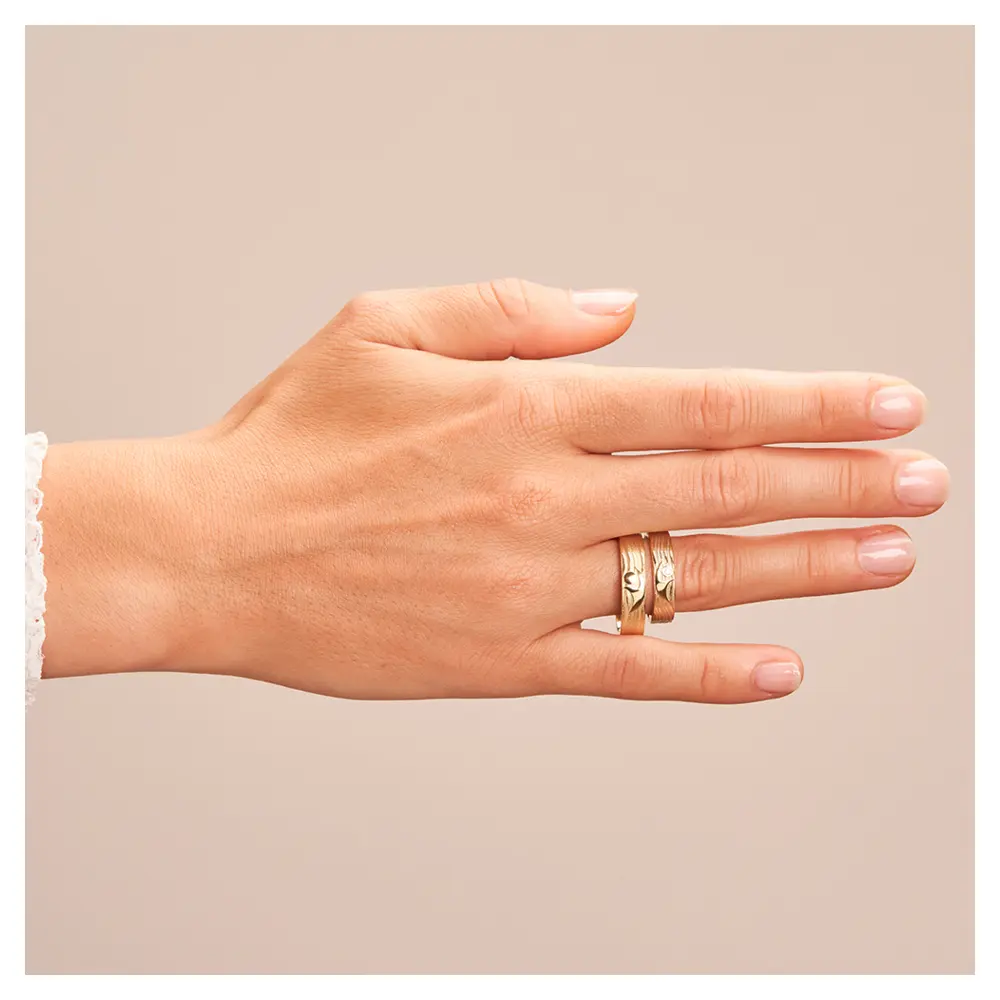 Eheringe aus Gelbgold mit interessantem Paarfigur-Symbol auf Hand