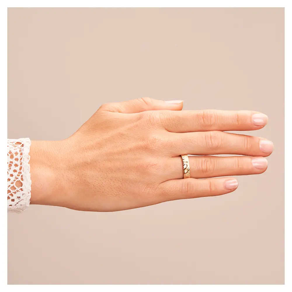 Ehering aus Gelbgold mit Symbol für Glaube Liebe Hoffnung und Brillant auf Hand