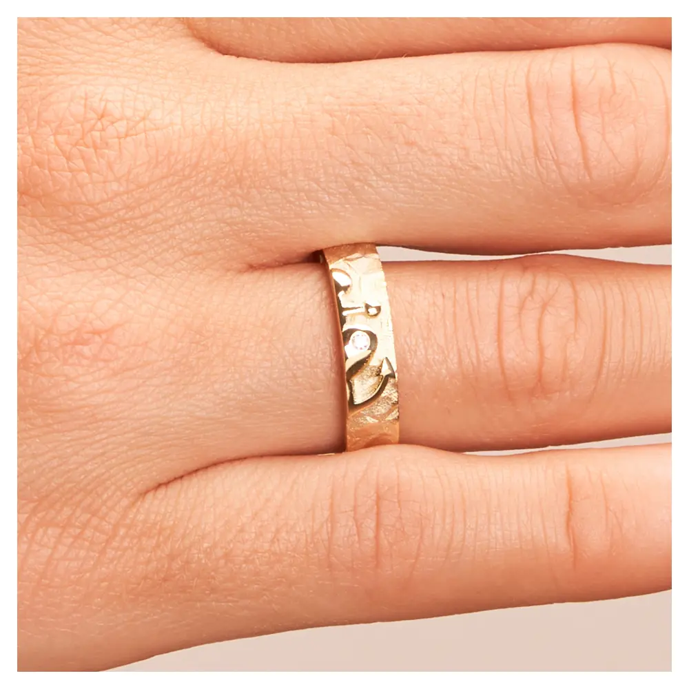 Ehering aus Gelbgold mit Symbol für Glaube Liebe Hoffnung und Brillant auf Hand im Zoom