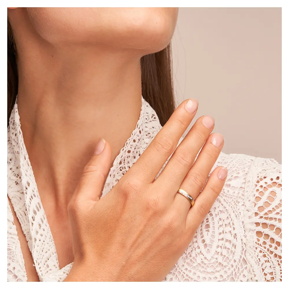 Ehering aus Platin & 585 Gelbgold mit Diamanten in graziler Rille auf Hand am Gesicht