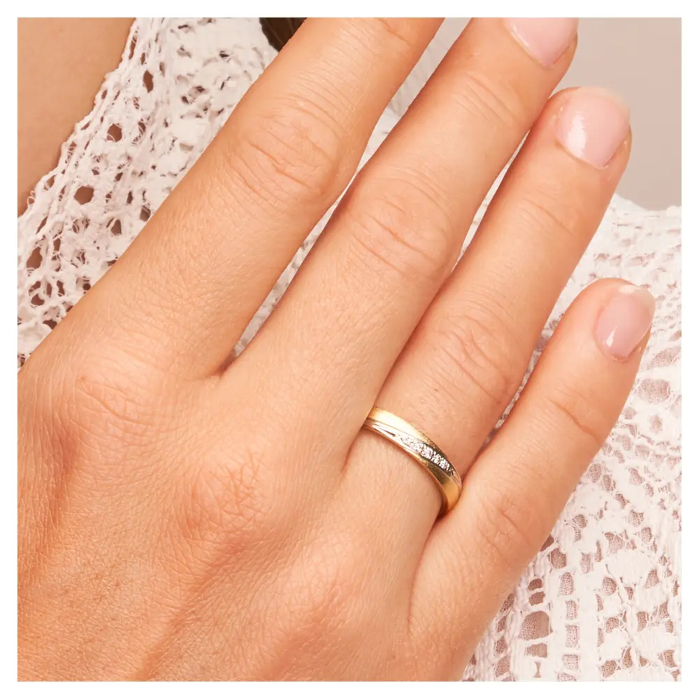 Ehering aus Platin & 585 Gelbgold mit Diamanten in graziler Rille auf Hand am Gesicht im Zoom
