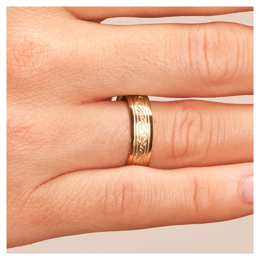 Ehering aus Gelbgold mit keltischem Muster auf Hand im Zoom