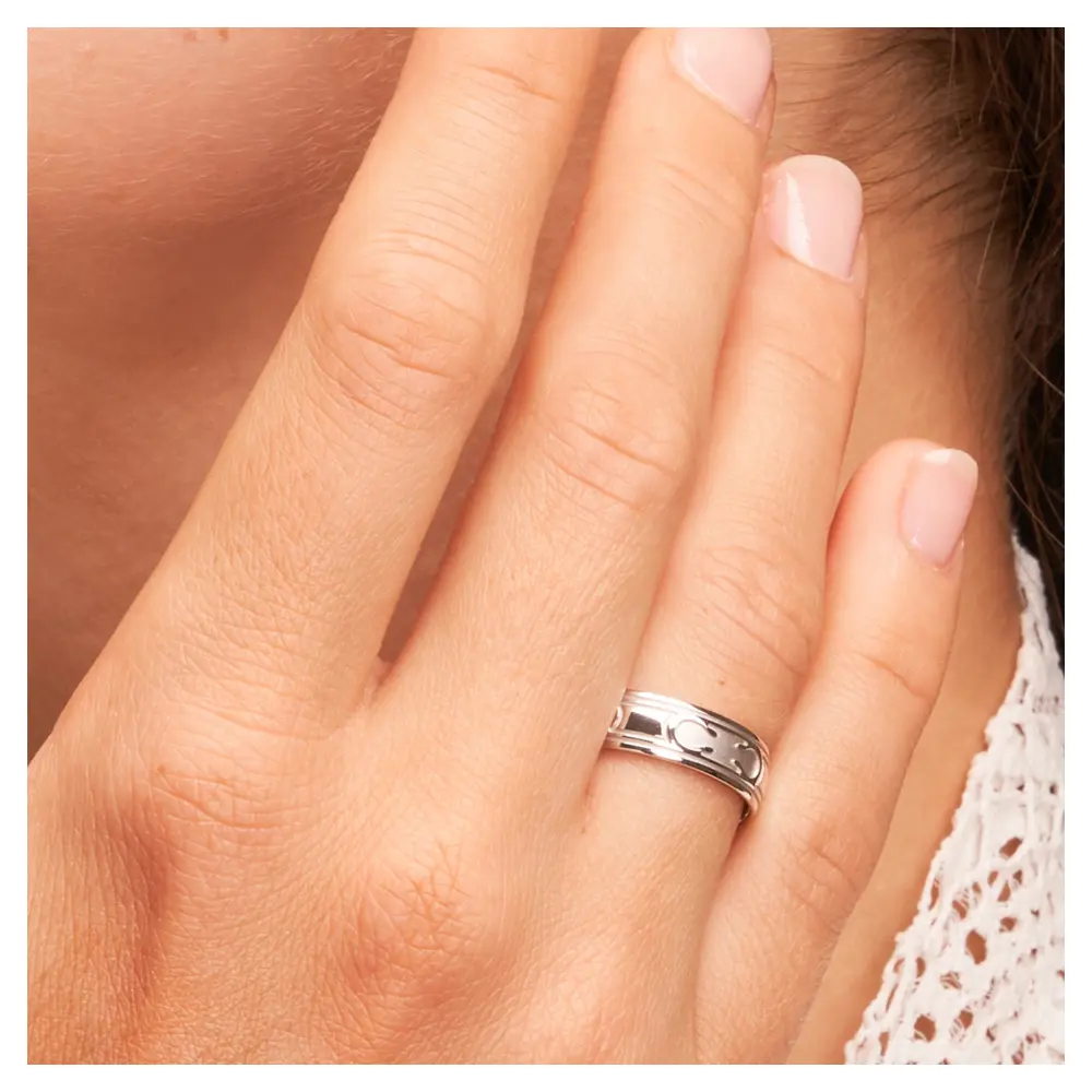 Außergewöhnliche Eheringe aus Weissgold mit interessantem Muster auf Hand am Gesicht im Zoom