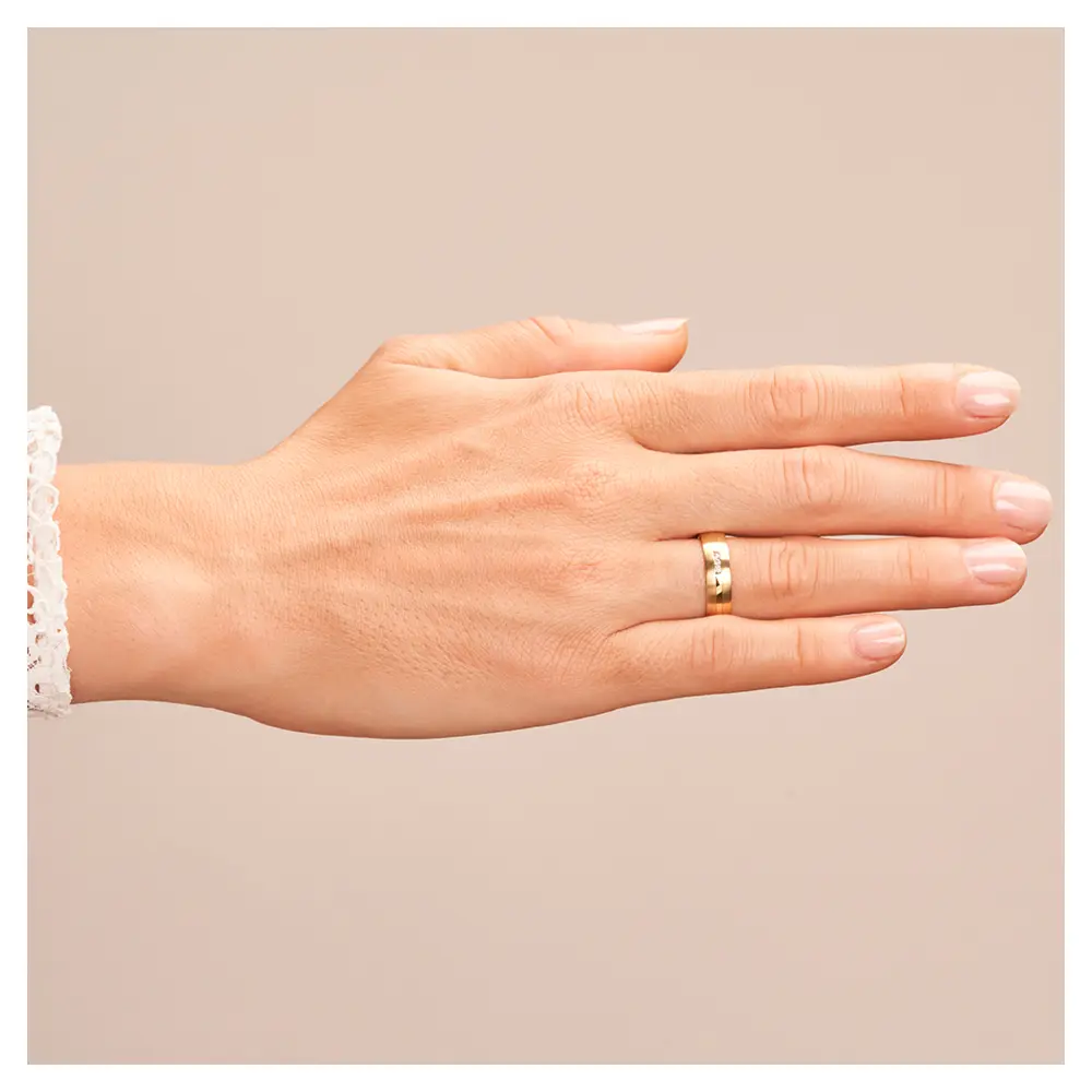 Eheringe aus Gelbgold mit Diamanten und matter Oberfläche auf Hand