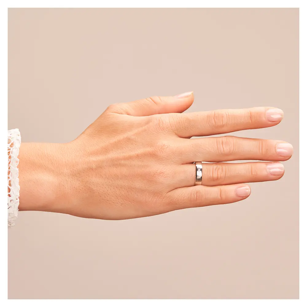 Matte Eheringe aus Weissgold mit polierten Rändern und 3 Diamanten im Kanal auf Hand