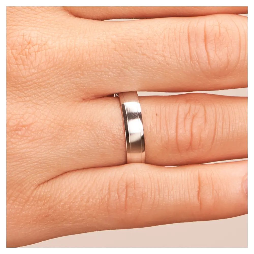 Matte Eheringe aus Weissgold mit polierten Rändern auf Hand im Zoom
