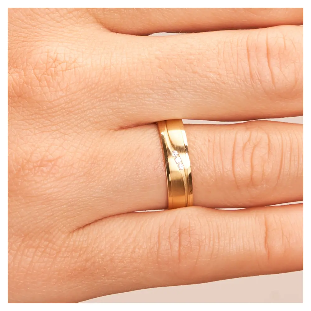 Eheringe aus Gelbgold mit polierten Rändern und Diamanten in sandmatter Rille auf Hand im Zoom