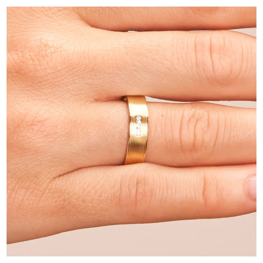 Konkave Eheringe aus Gelbgold mit Diamanten und polierten Rändern auf Hand im Zoom