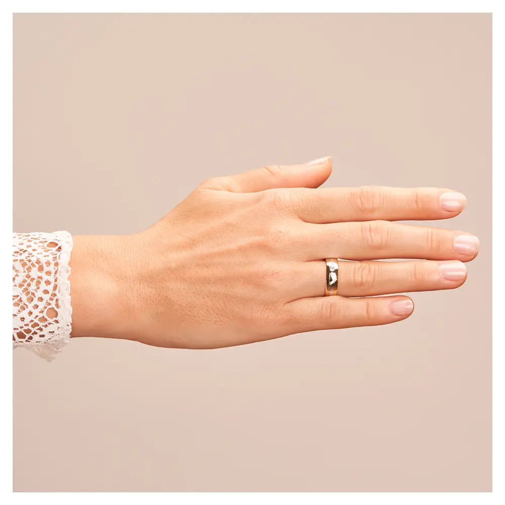 Trauring aus Weißgold und Gelbgold mit glänzenden Diamanten auf Hand