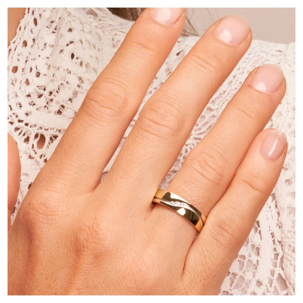 Ehering aus Gelbgold mit drei Diamanten in Weißgoldrille auf Hand am Gesicht im Zoom