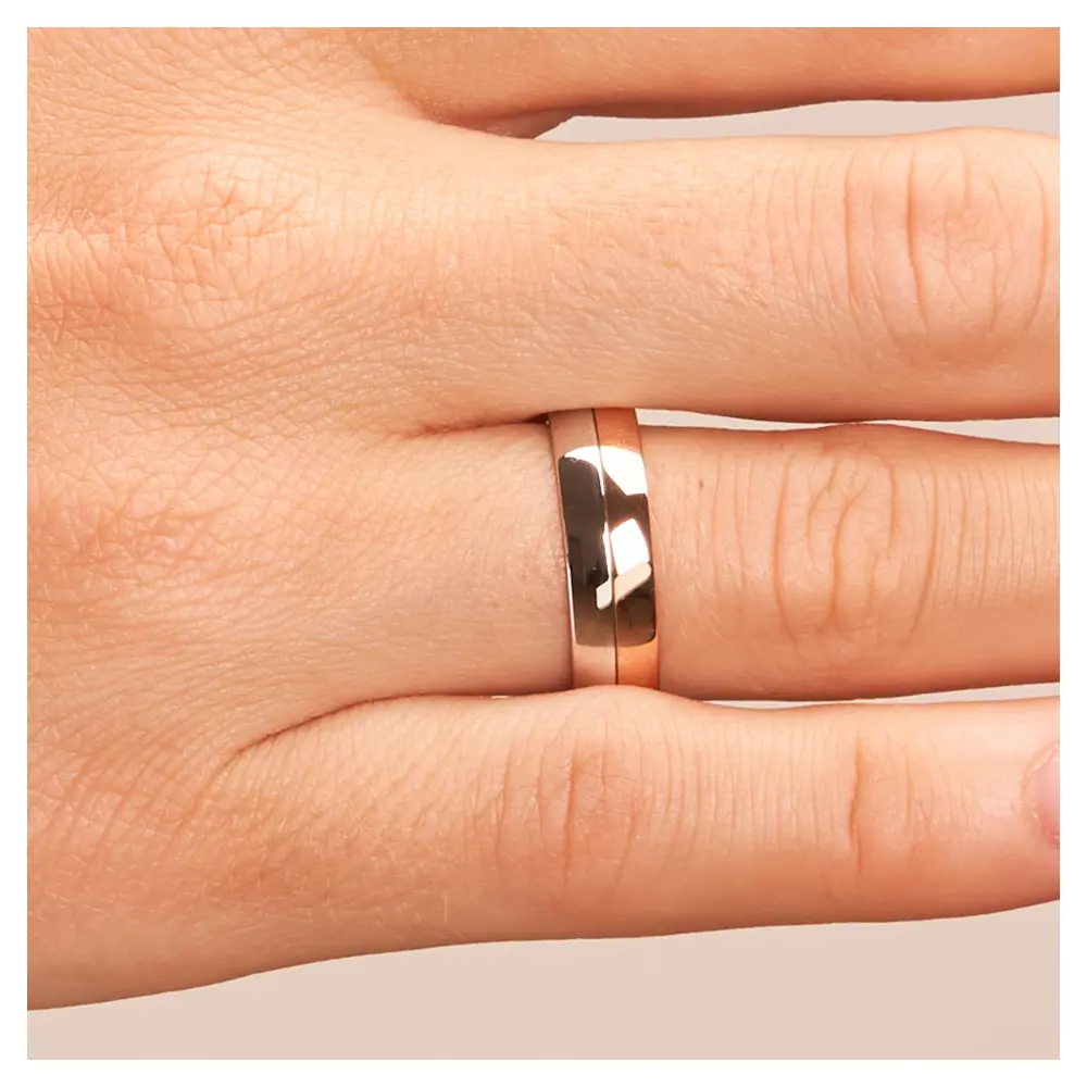 Trauring in Rotgold/Weißgold auf Hand im Zoom