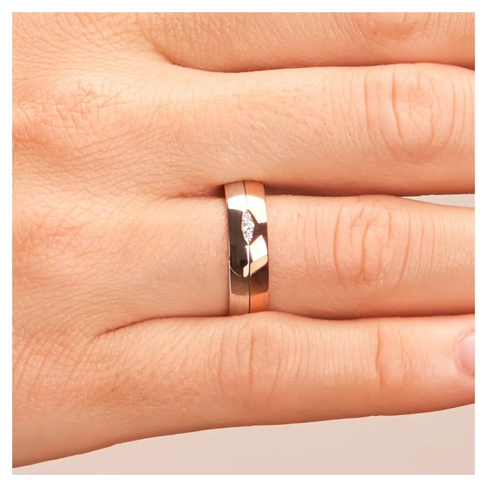 Trauring in Rotgold/Weißgold mit drei Diamanten in blattförmiger Fassung auf Hand im Zoom