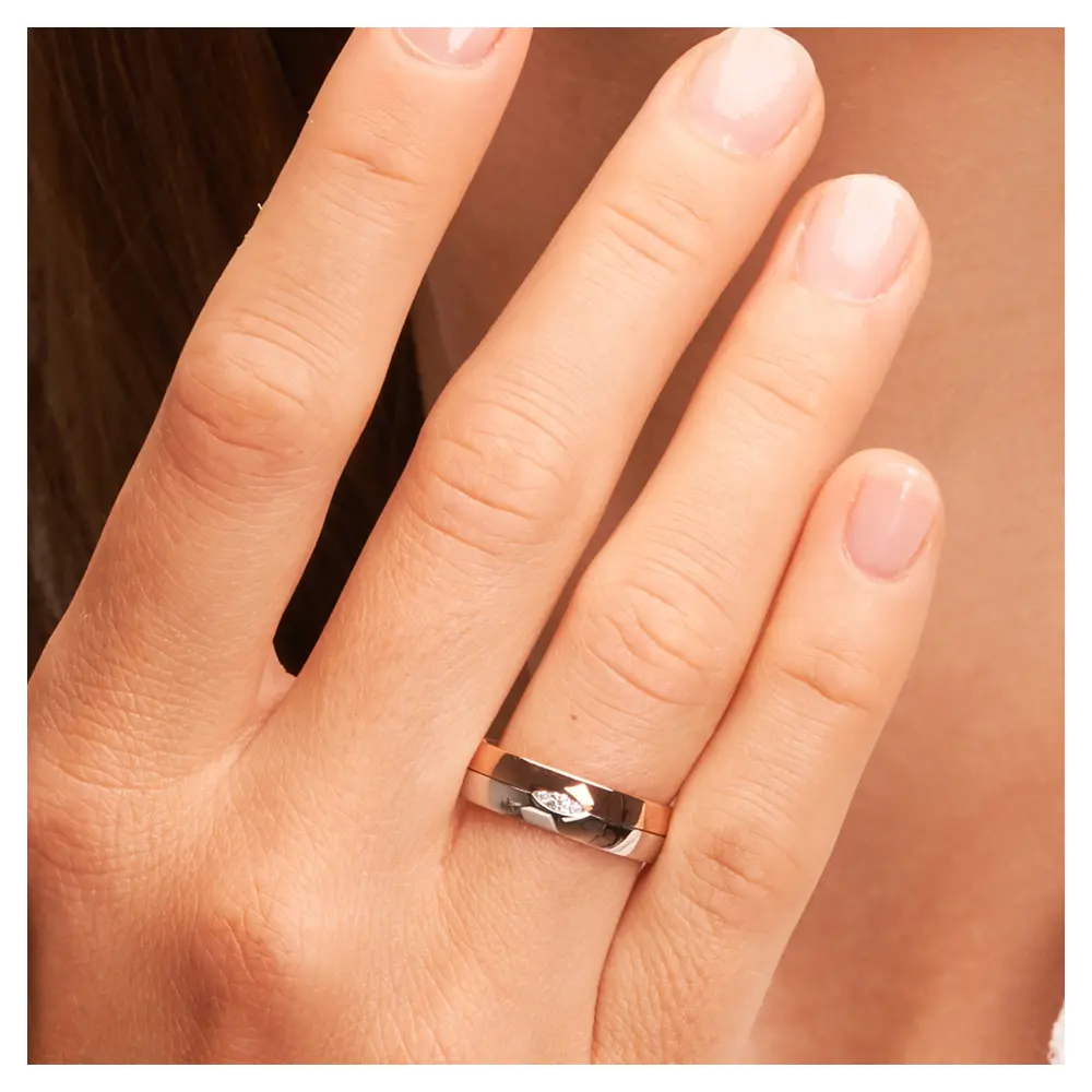 Trauring in Rotgold/Weißgold mit drei Diamanten in blattförmiger Fassung auf Hand am Gesicht im Zoom