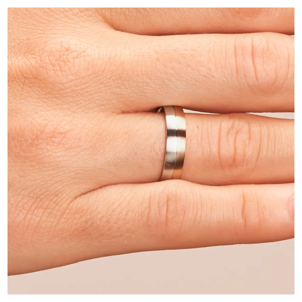 Trauring in Palladium 500 und Roségold auf Hand im Zoom