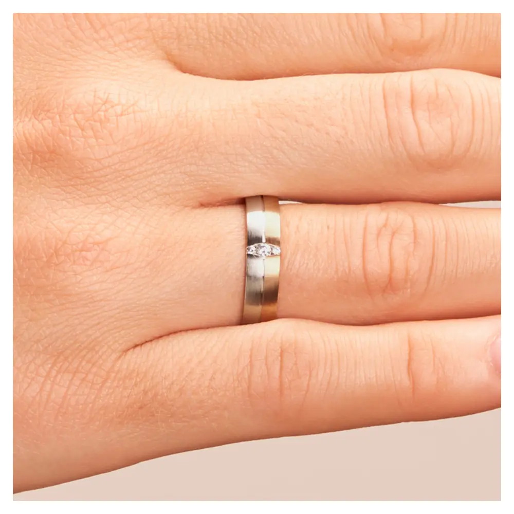 Trauring in Palladium 500 und Roségold mit drei Diamanten in ovaler Fassung auf Hand im Detail