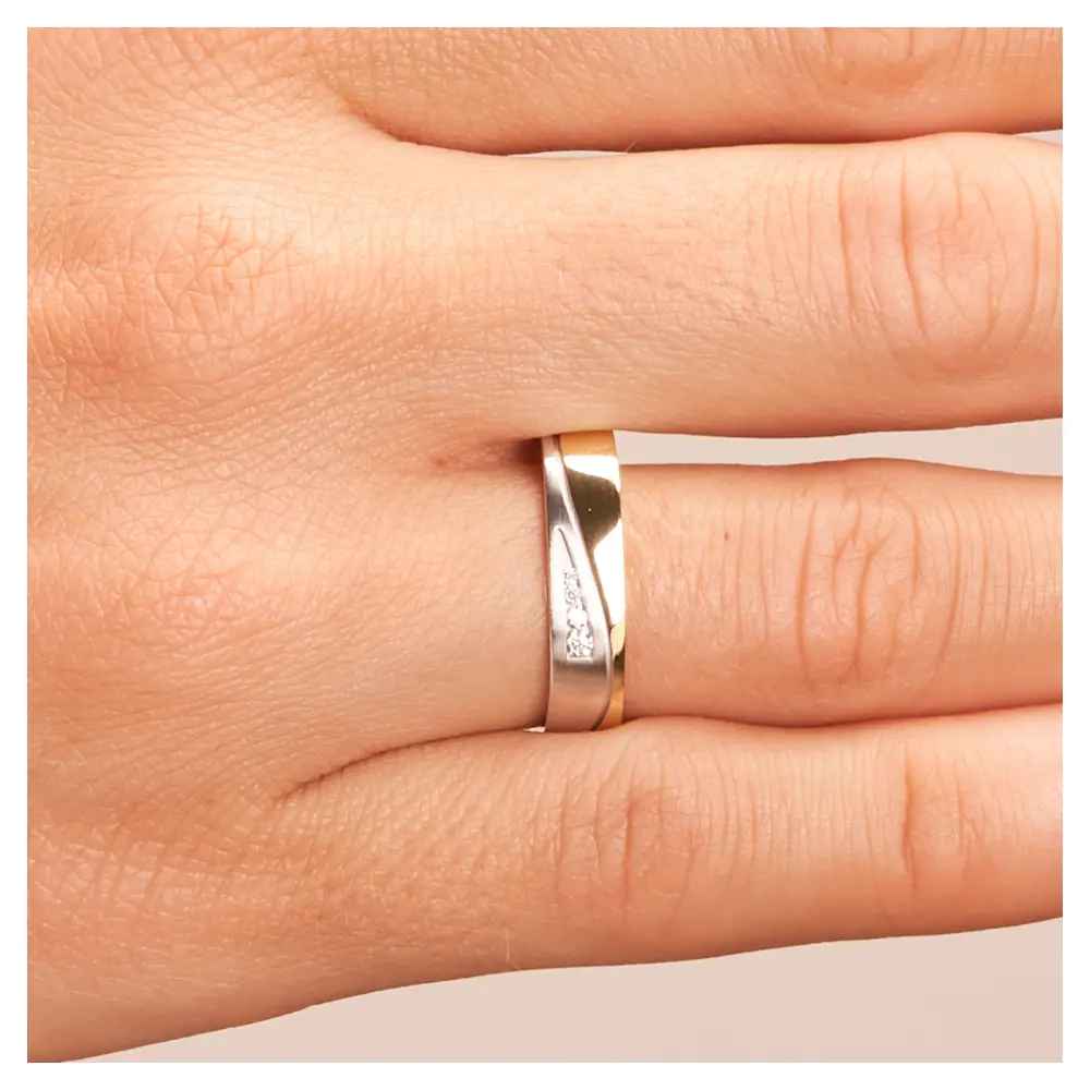Ehering aus Weiß- & Gelbgold mit Diamanten auf Hand frontal im Zoom