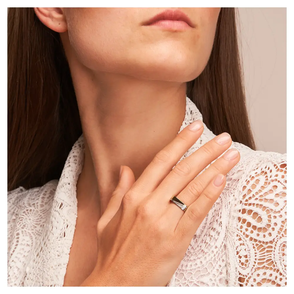 Ehering aus Palladium 500 und Gelbgold mit vier Diamanten in eckiger Form auf Hand am Gesicht