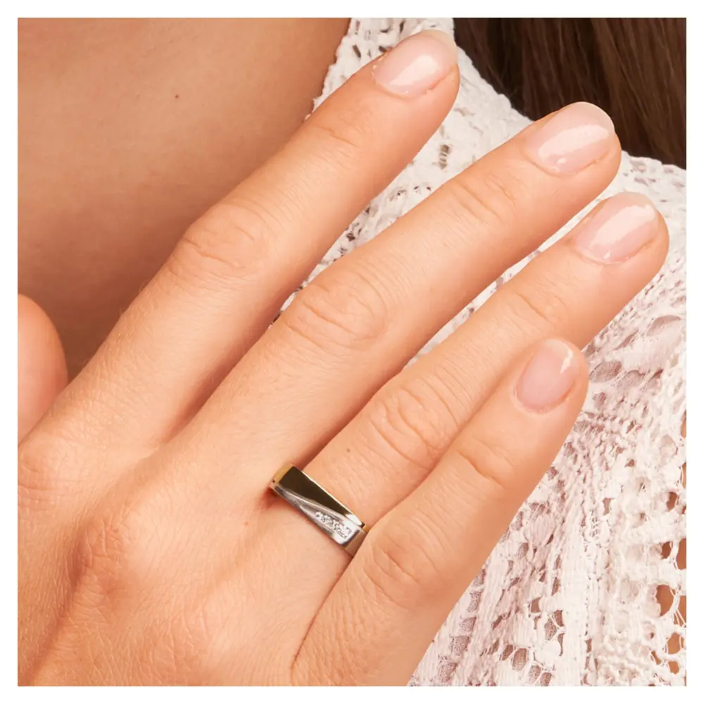 Ehering aus Palladium 500 und Gelbgold mit vier Diamanten in eckiger Form auf Hand am Gesicht Zoom