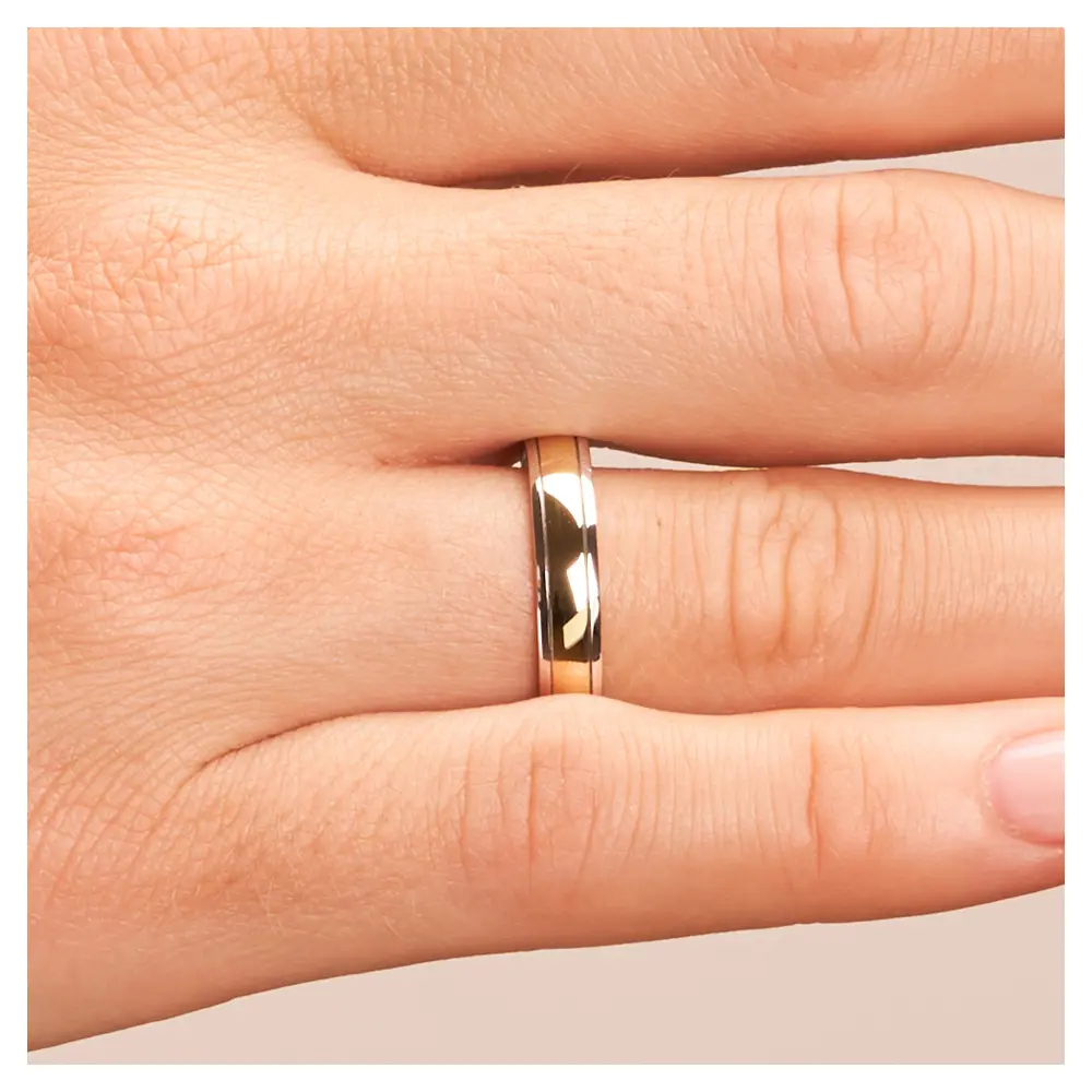 Ehering aus Weißgold und Gelbgold auf Hand im Zoom