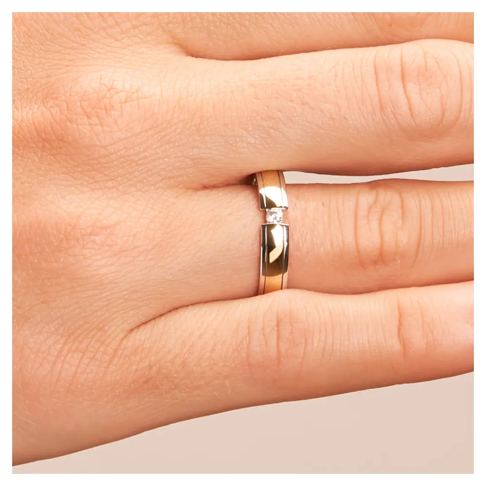 Ehering aus Weißgold und Gelbgold mit rundem Diamanten auf Hand im Zoom