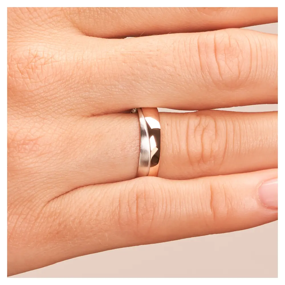 Ehering in poliertem Rotgold und mattem Weißgold auf Hand im Zoom