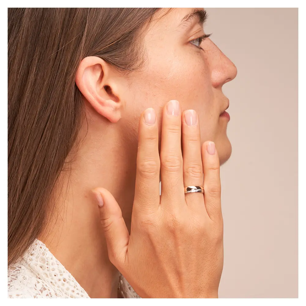 Ehering in poliertem Rotgold und mattem Weißgold mit 7 Diamanten auf Hand am Gesicht