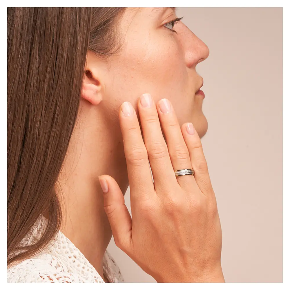 Ehering aus Palladium 500/Gelbgold sandmatt mit fünf Diamanten auf Hand am Gesicht