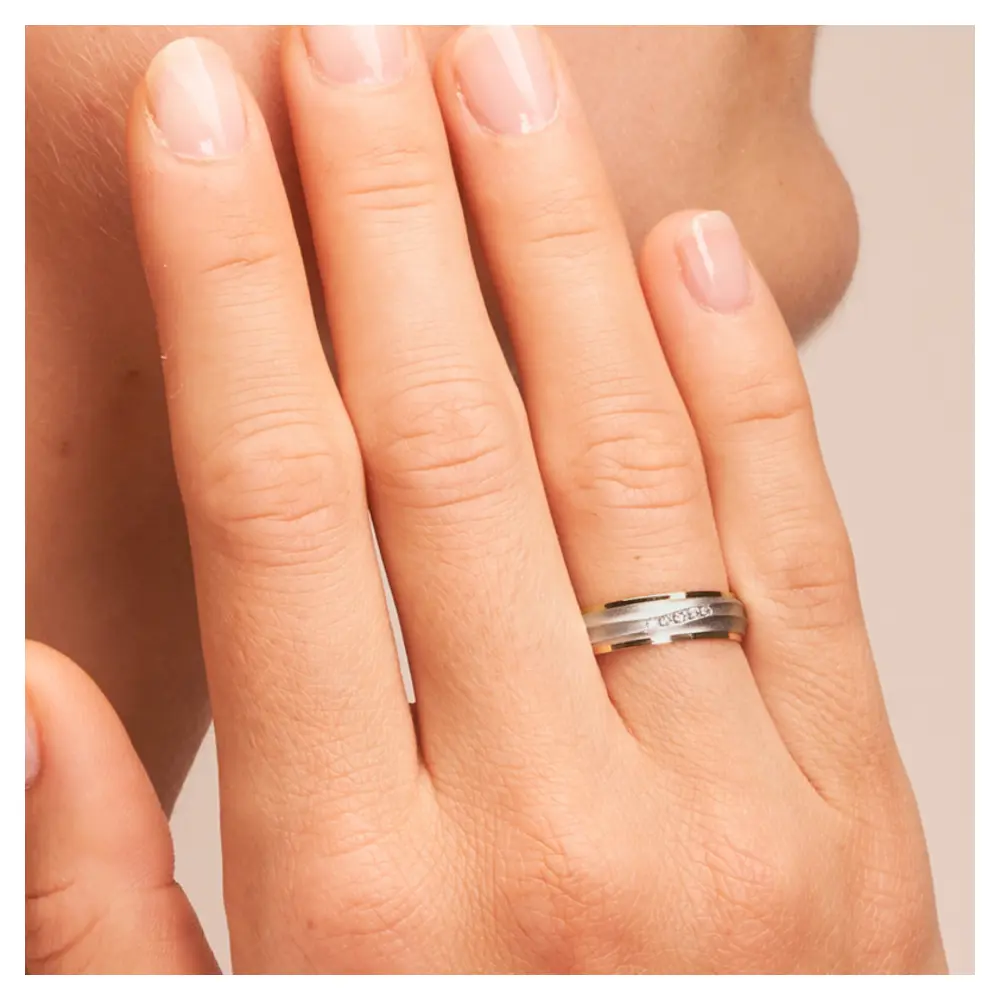 Ehering aus Palladium 500/Gelbgold sandmatt mit fünf Diamanten auf Hand am Gesicht im Zoom