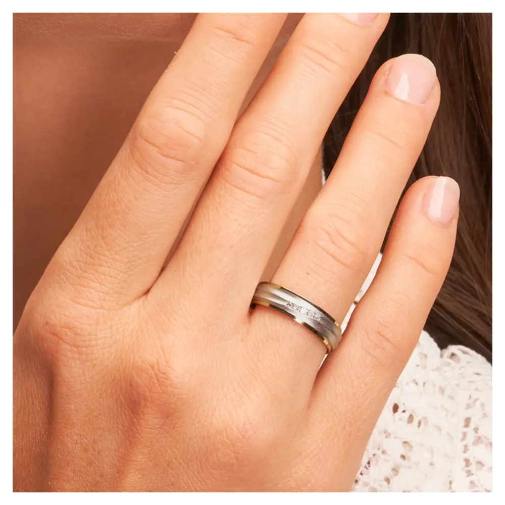 Ehering aus Palladium 500/Gelbgold sandmatt mit fünf Diamanten auf Hand am Gesicht im Zoom II 