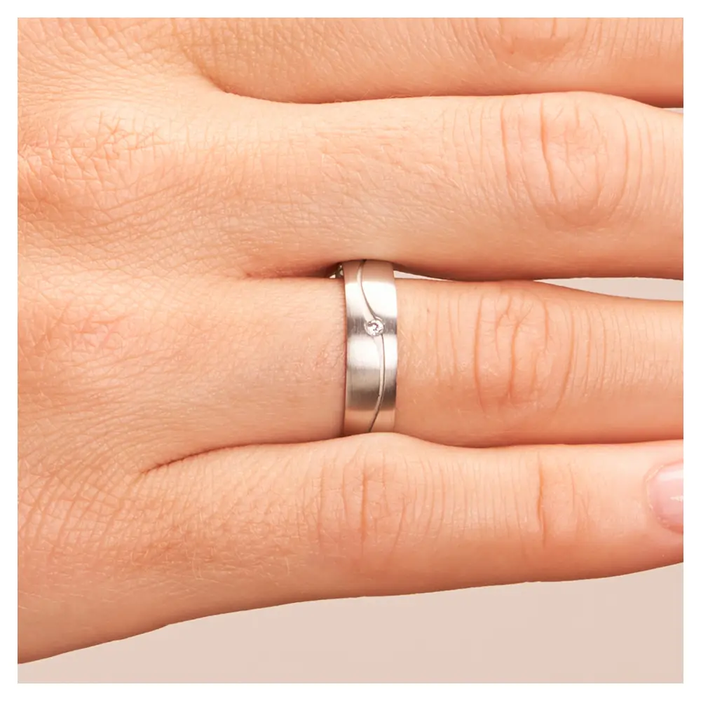 Längsmatte Eheringe aus Weißgold mit Rille und Diamanten auf Hand im Zoom