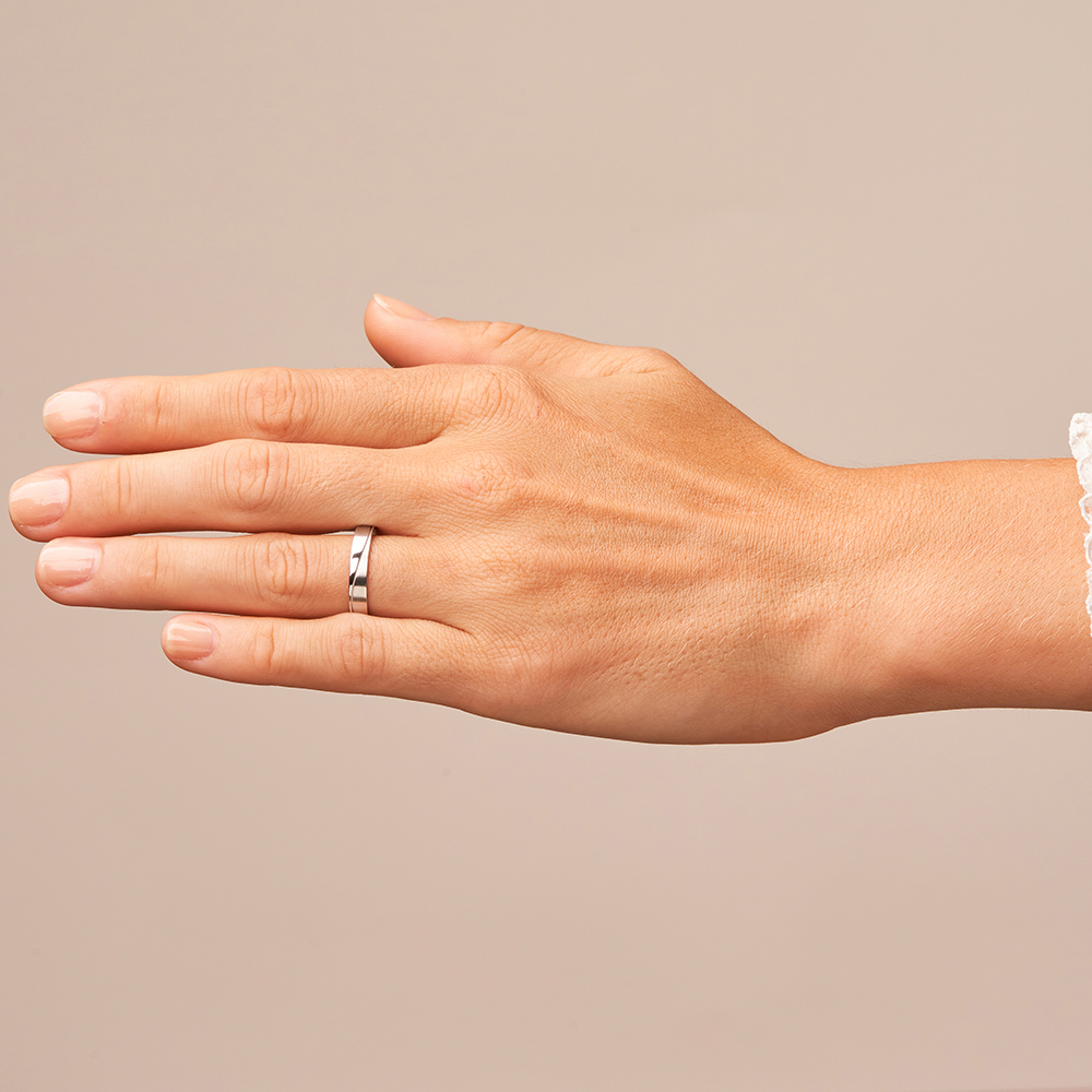 Eheringe aus Platin mit geschwungener Rille auf Hand
