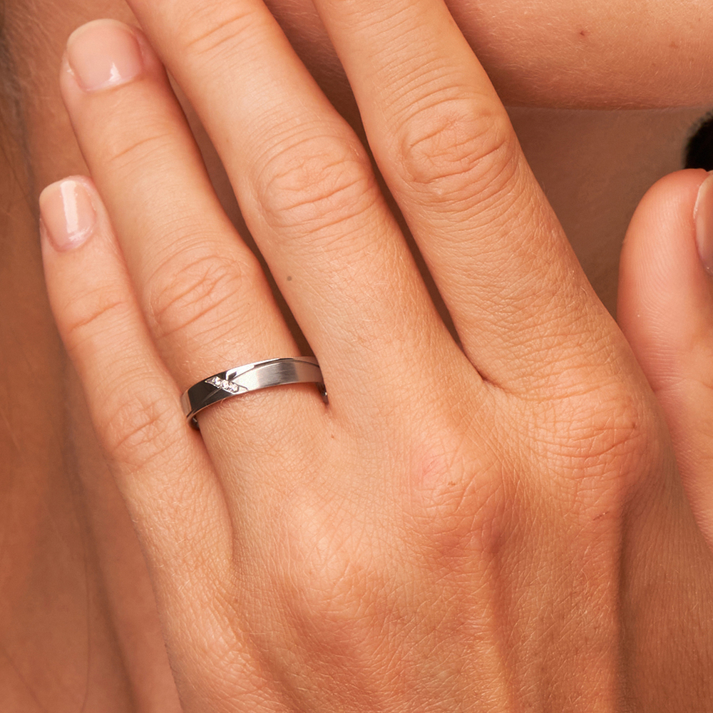 Palladium mit Diamant gewelltem sandmattem Rillen auf Hand am Gesicht in Nahaufnahme