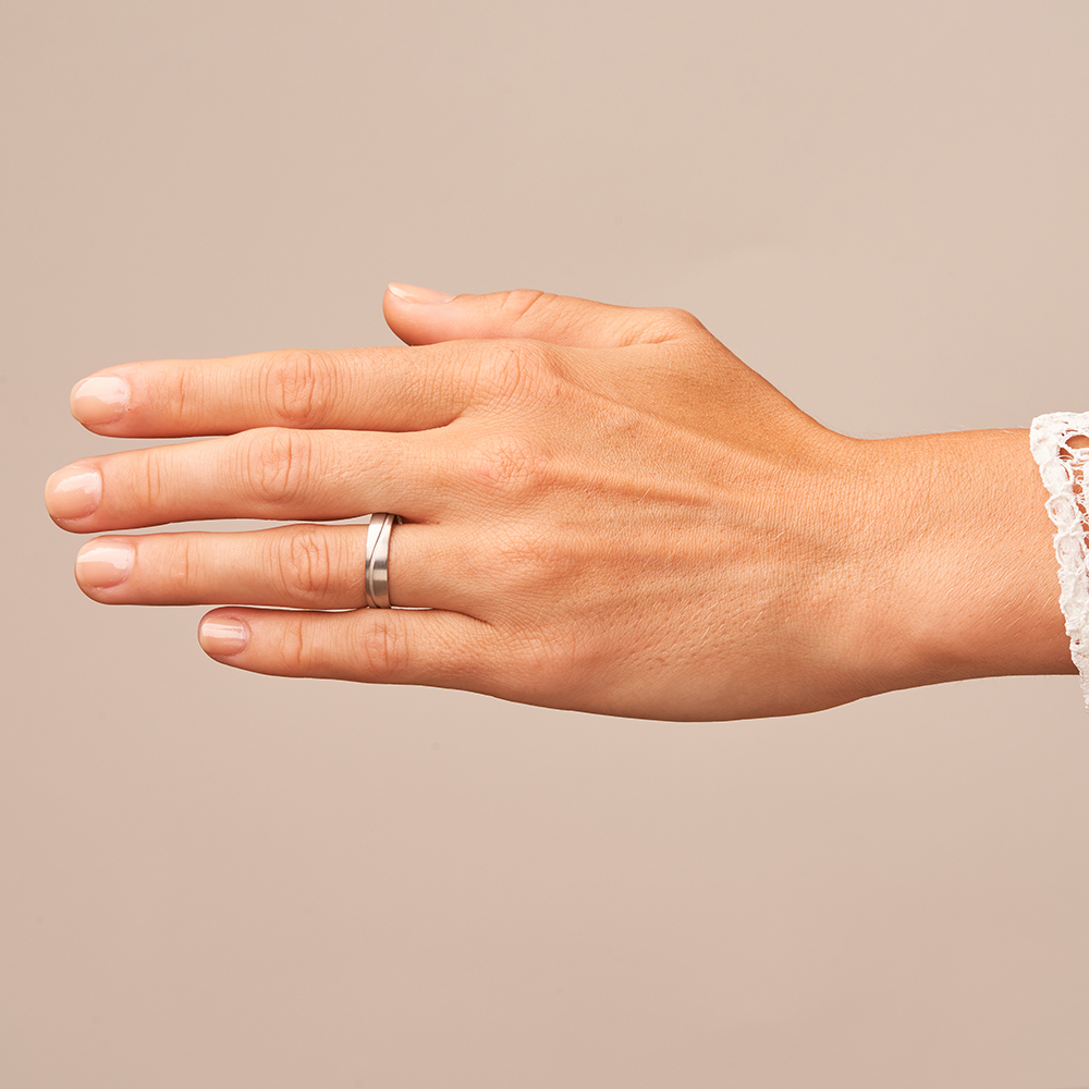 Längmattierte Weissgold Trauringe mit gewellter sandmatter Rille auf Hand
