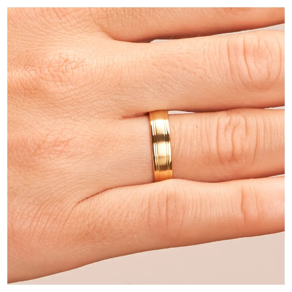 Matte Gelbgold Eheringe mit polierten Rillen auf Hand im Zoom