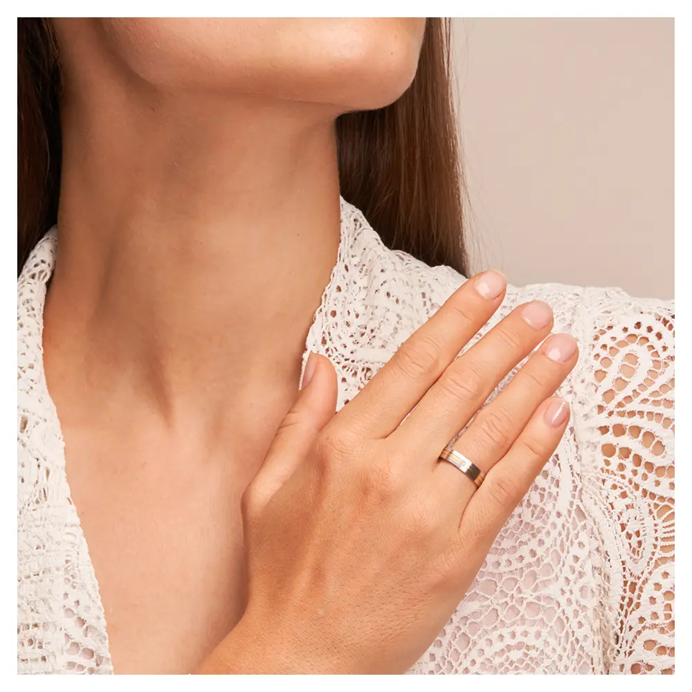 Weißgold und Gelbgold Eheringe längsmattiert mit Diamanten auf Hand am Gesicht