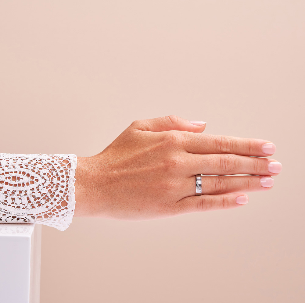 Eheringe aus Platin mit Diamanten und Längsmattierung auf Hand