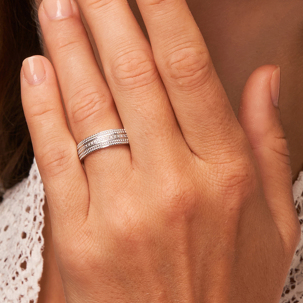 Polierter Platin Ehering mit Millgriff Design und Diamantenband auf Hand in Nahaufnahme