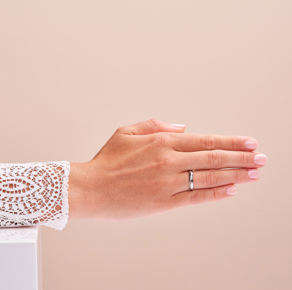 Aufnahme von Eheringen aus poliertem Edelstahl mit Diamanten in sandmattierter Wellenrille auf Hand